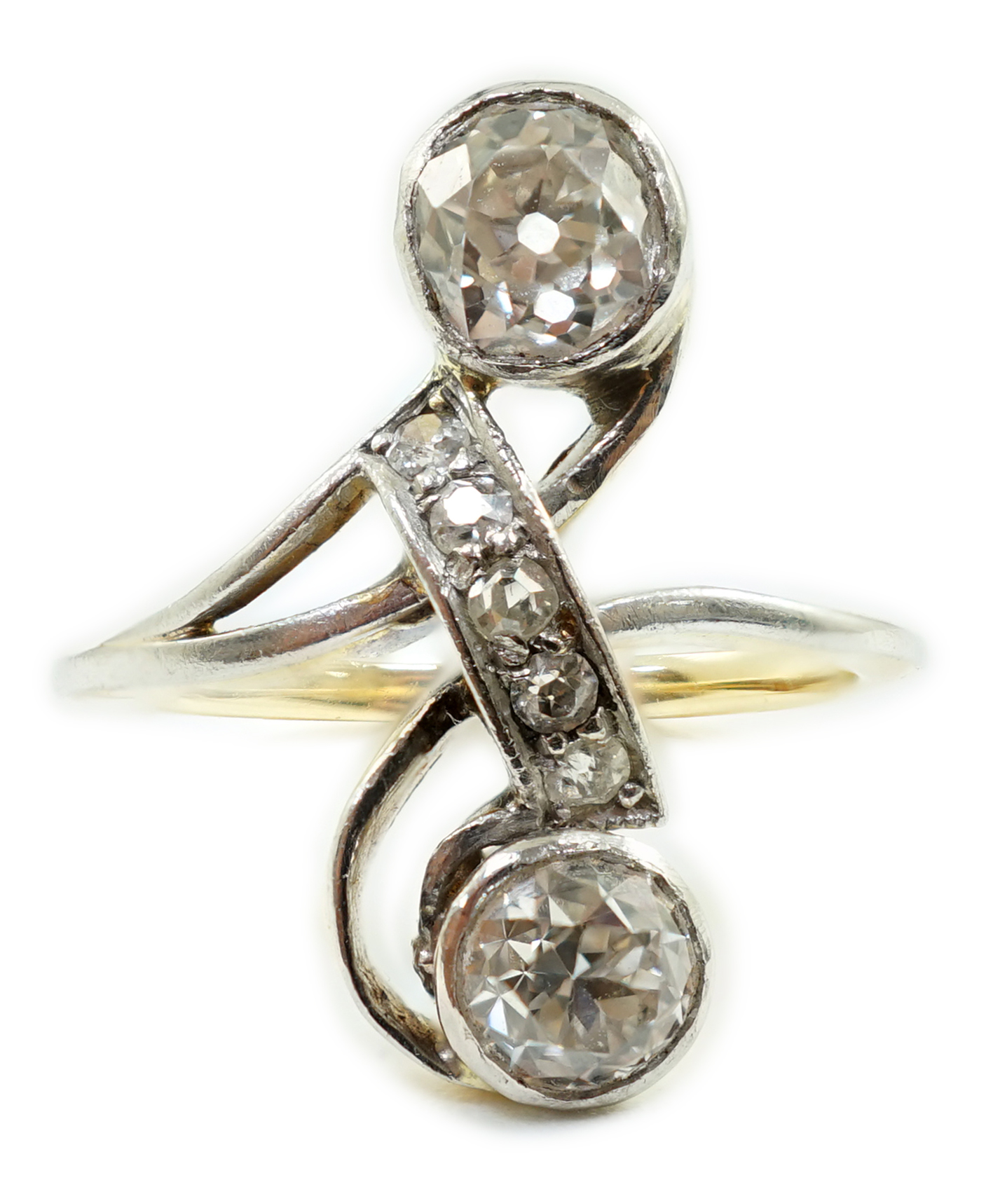 An early to mid 20th century gold and two stone diamond cross over ring, with five stone diamond chip setting